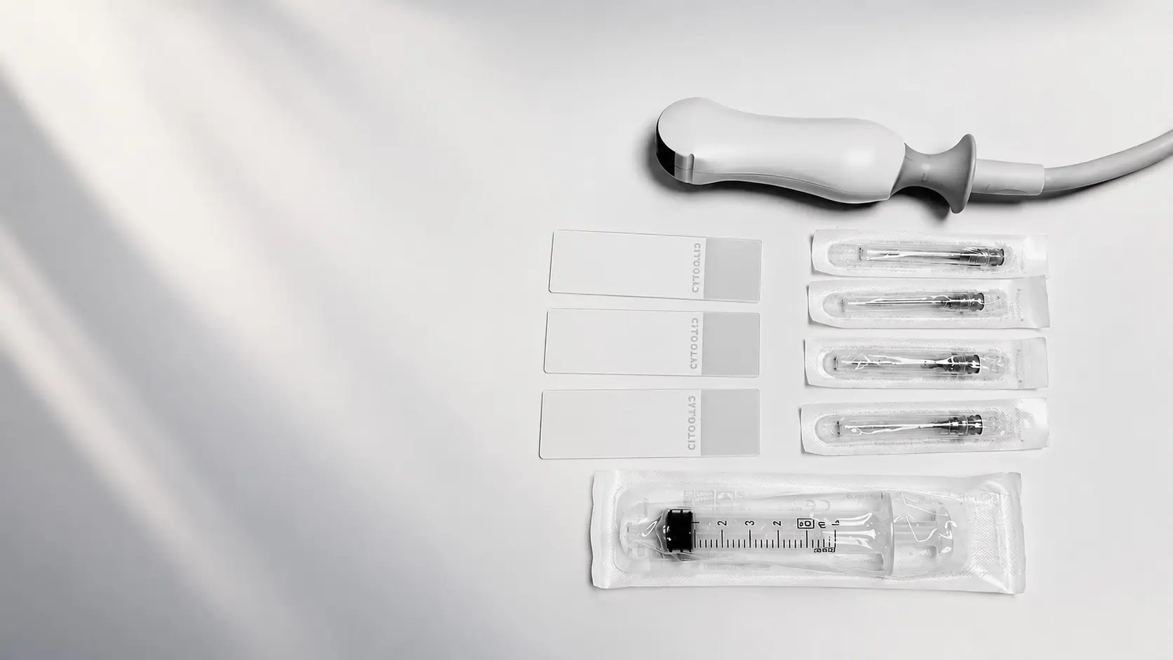 Matériel de prélèvement échoguidé : sonde d'échographie, lames de cytologie, aiguilles et seringue